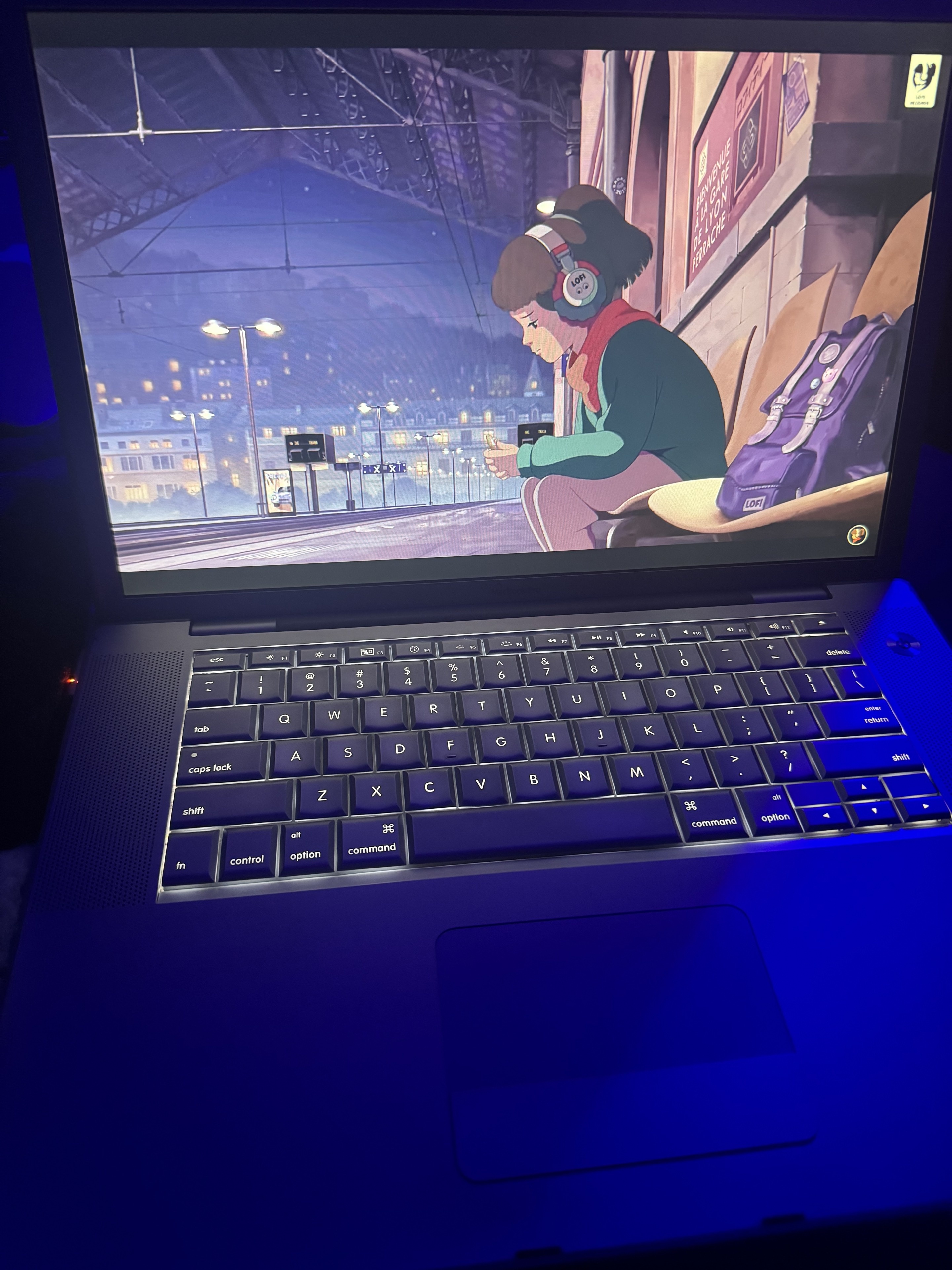 Laptop showing a lo-fi wallpaper under blue lighting